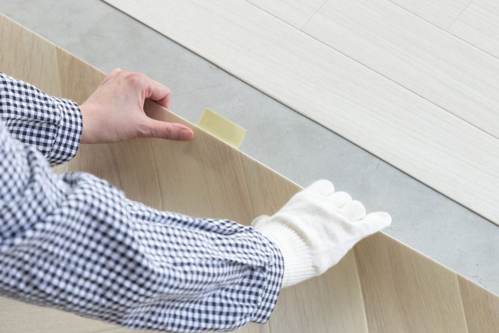 ラグリエのツートンフロアマット 木目柄 床DIY中 吸着滑り止めシートを使ってマットを設置している様子 賃貸住宅の床リフォームイメージ