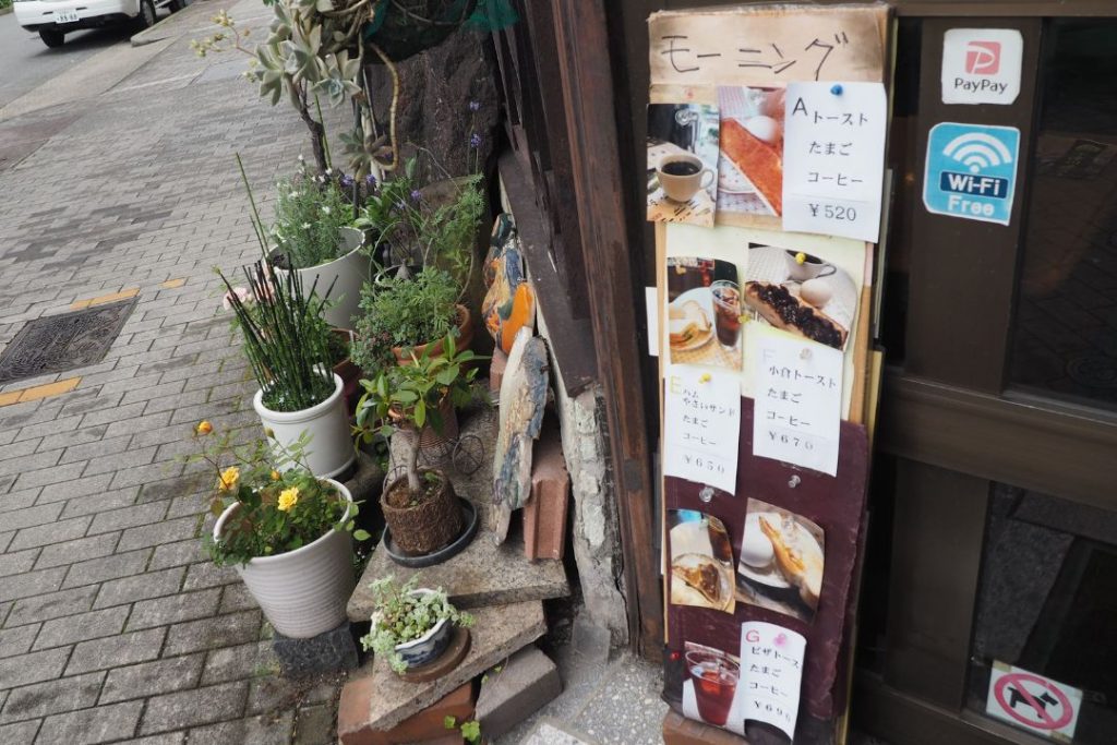 喫茶エーデルワイス入口前のモーニングメニュー看板。レトロな外観と植物が並ぶ、名古屋の昔ながらの喫茶店らしい雰囲気。