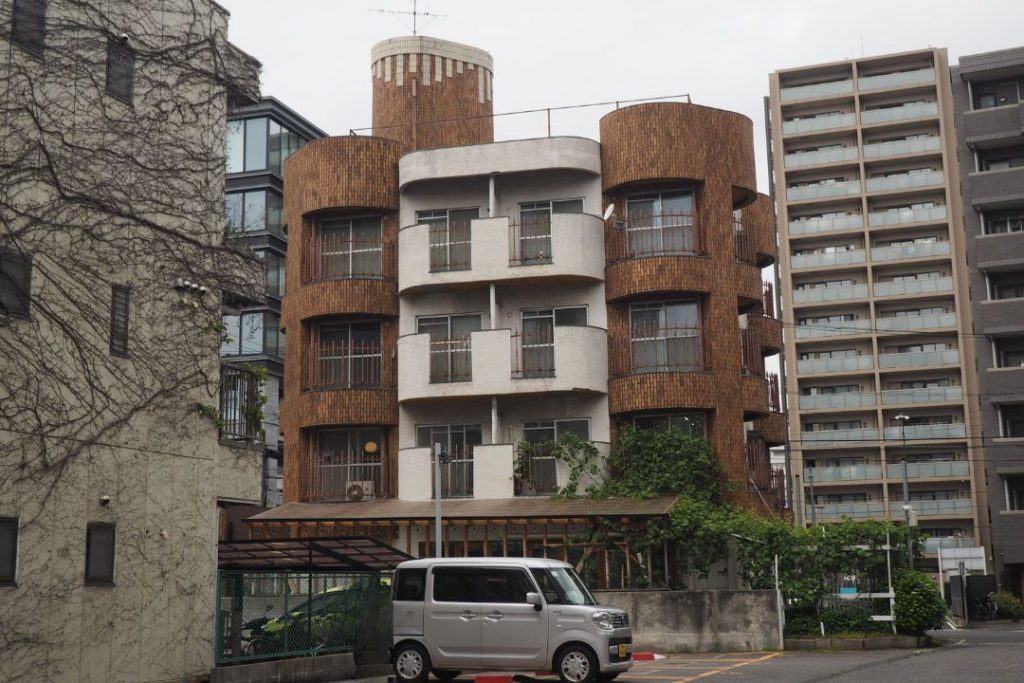名古屋市東区の街歩きで見つけた丸みのある集合住宅。曲線的な外壁とブラウン系のタイルが印象的なレトロ建築。