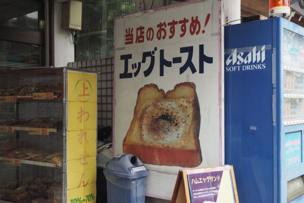 名古屋市東区の街歩きで見つけたエッグトーストの看板。喫茶店らしい写真付きの看板と、われせんのショーケースが並ぶ外観。