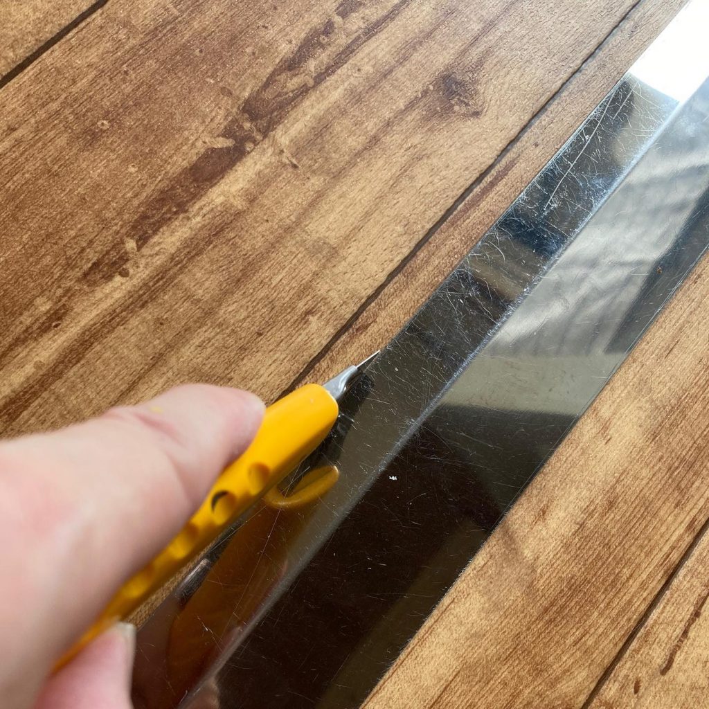 定規を当てながらクッションフロアの継ぎ目をカットしている様子