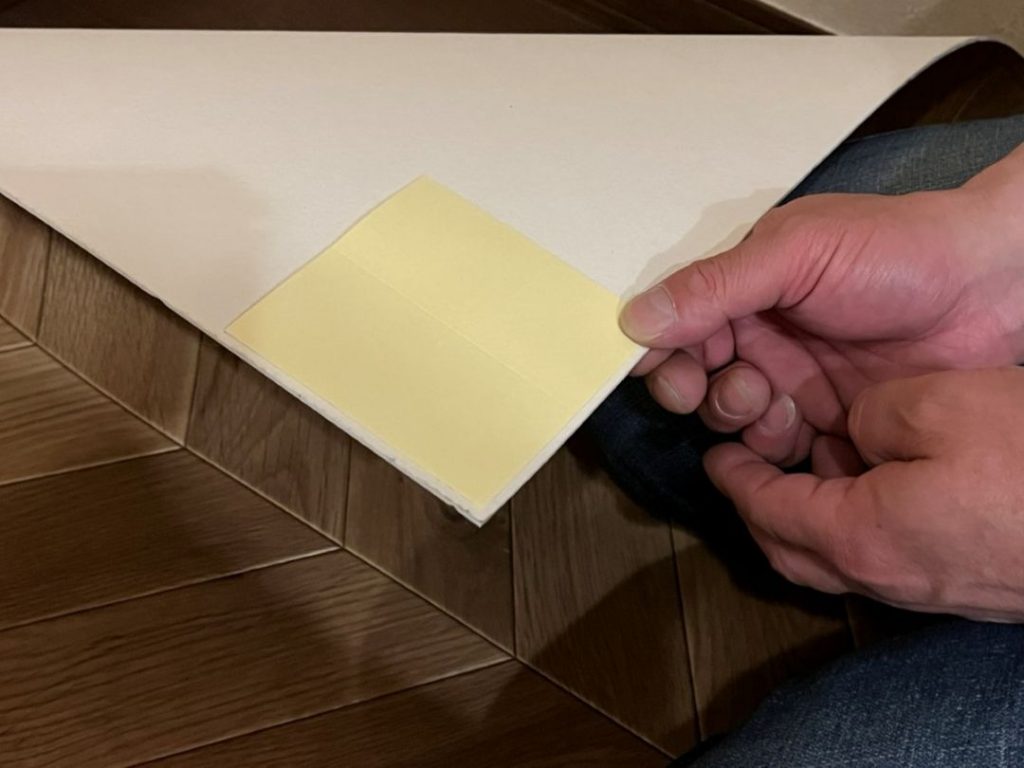 ペットマットの裏面に吸着滑り止めシートを貼る様子