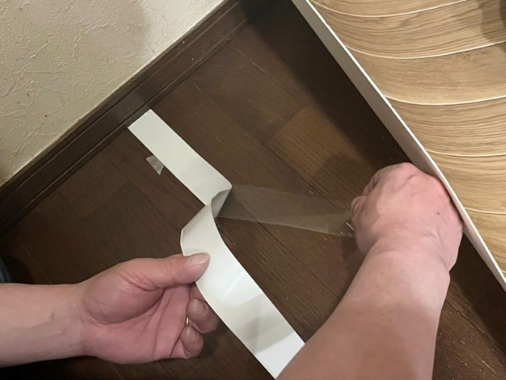 ペットマットの継ぎ目に吸着滑り止めテープを貼る様子