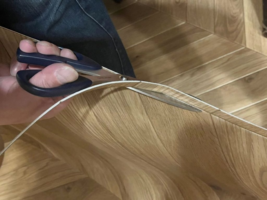 エルカムヘリンボーンの余分な部分をハサミでカットする様子