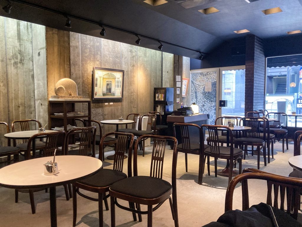 豊橋の喫茶フォルム店内。丸テーブルと椅子が並ぶ落ち着いた空間