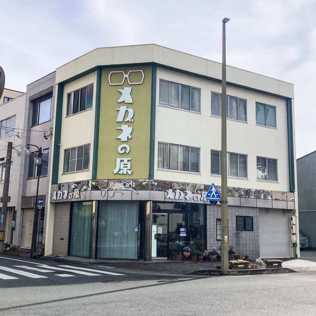豊橋の街に建つ「メガネの原」の外観。大きなメガネのロゴが印象的なレトロビル