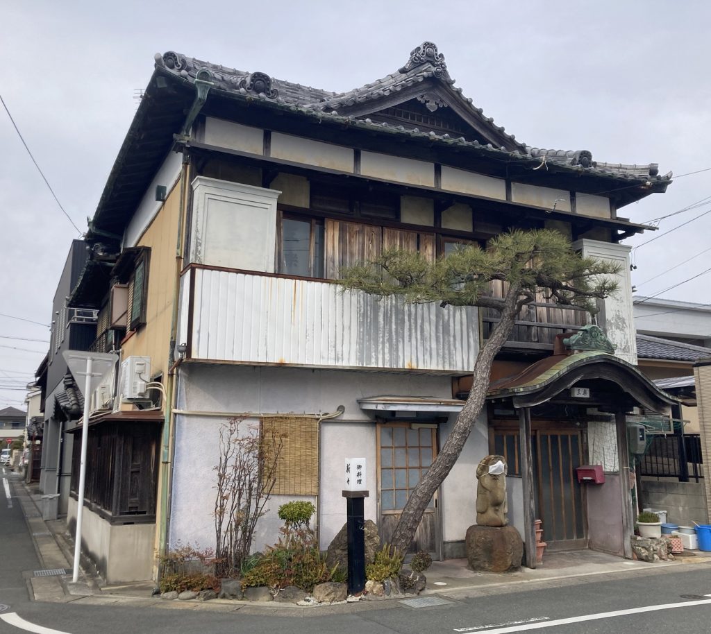 豊橋の街角に建つ、松の木と瓦屋根が印象的な和風建築の外観