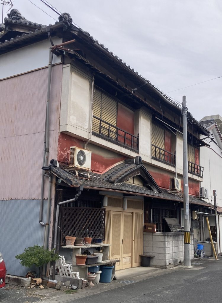 豊橋の街で見つけた、赤い壁と瓦屋根が残る古い建物外観