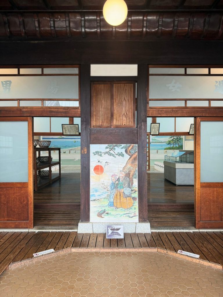 「男湯」「女湯」の文字と高砂のタイル画が残る子宝湯の入口